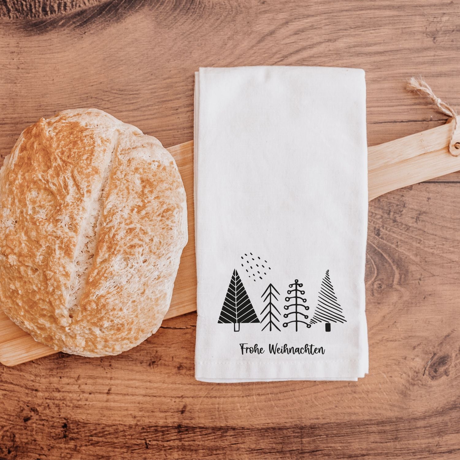 Weißes Geschirrtuch mit schwarzer Tannenbaum-Grafik und "Frohe Weihnachten" -Aufdruck