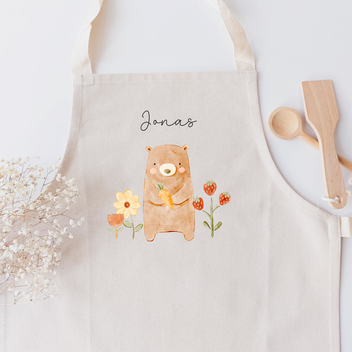 Kinderschürze mit niedlicher Bärchen-Grafik und personalisiert mit einem Namen in schwarzer Kalligrafie