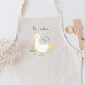 Kinderschürze mit hübscher Gänschen-Grafik und personalisiert mit einem Namen in schwarzer Kalligrafie