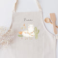 Kinderschürze mit hübscher Schäfchen-Grafik und personalisiert mit einem Namen in schwarzer Kalligrafie