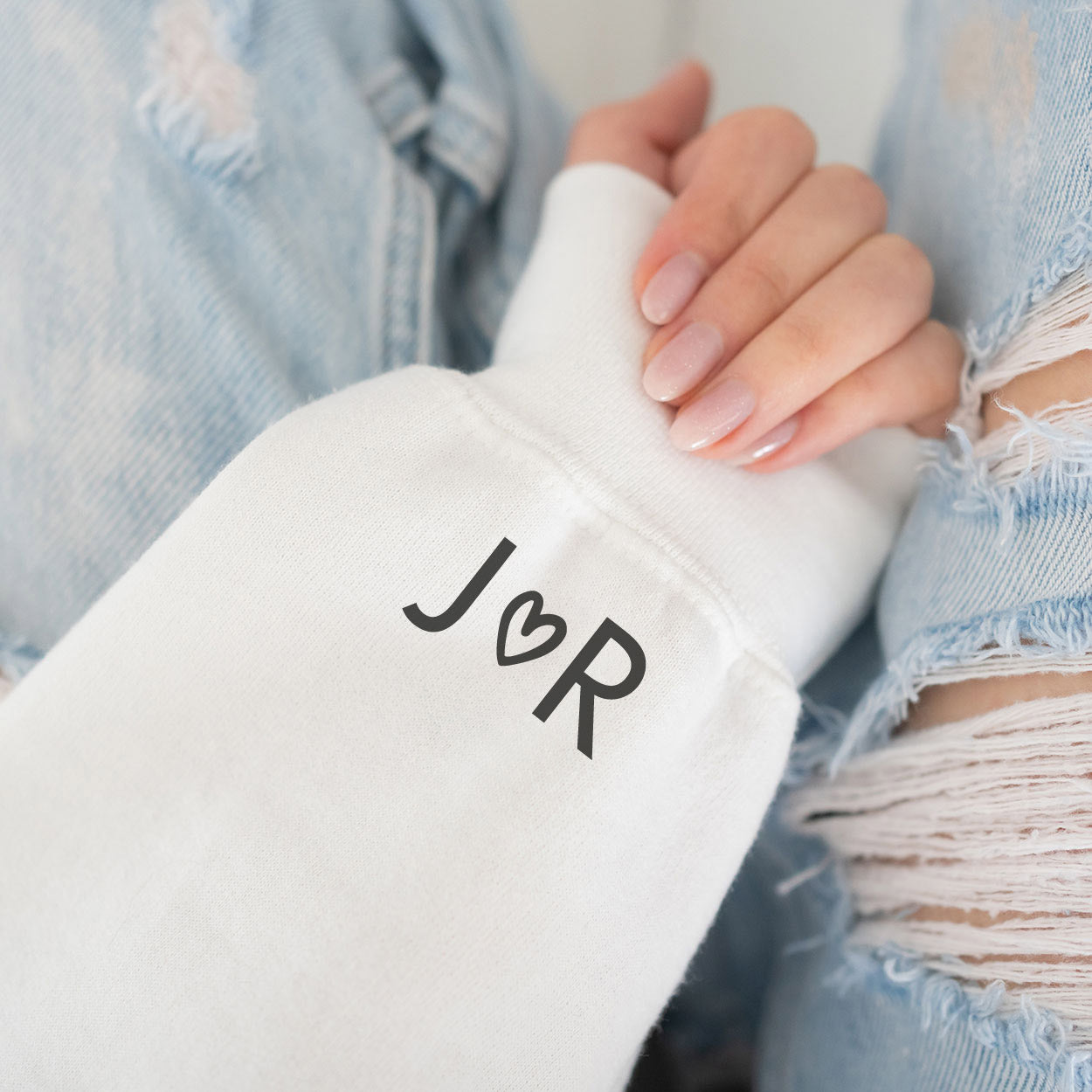 Beispielbild: versteckte Personalisierung am Sweater-Ärmel (Initialen Brautpaar mit Herzchen)